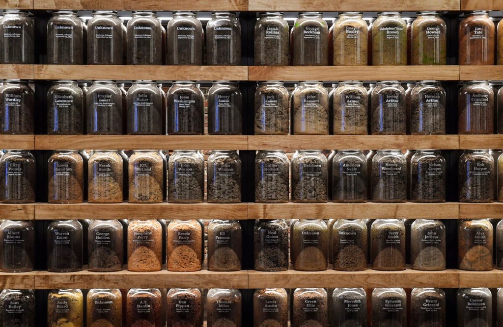 Many bottles of different-colored dirt on shelves